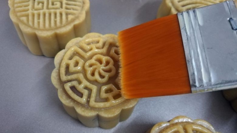 广式蛋黄月饼,取少许鸡蛋黄加少许水稀释后,用毛刷在月饼上薄薄刷上一层蛋液。