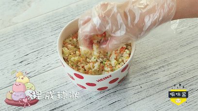 杂蔬三文鱼饭团,将米饭揉成饭团。
ps：饭团一定要趁热捏，米饭的粘性会更好，带上一次性手套更卫生哦~