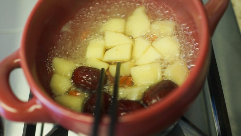 超好吃的苹果炖牛腩,6、 取砂锅一个加入开水、一个苹果去皮切块煮五分钟筷子可以轻轻夹断