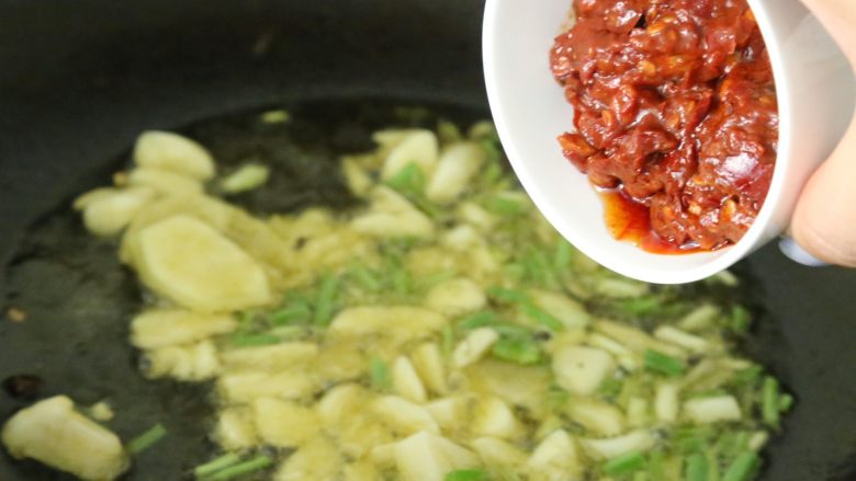 水煮肉片,放入<a style='color:red;display:inline-block;' href='/shicai/ 705'>豆瓣酱</a>,超出红油后,放一碗水,熬煮充分。约10分钟。