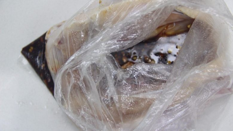 周末大餐——秘制烤整鸡,取一个食品袋把鸡身放入,后倒入调味料,扎紧袋子,均匀的晃动鸡身,使调味料均匀涂抹鸡身每处