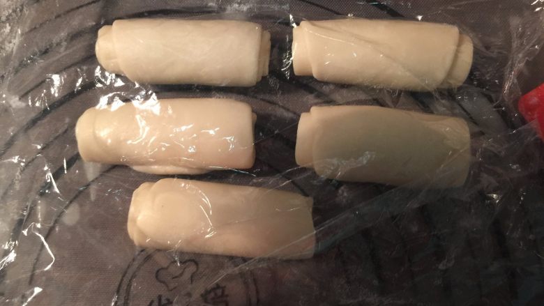 馅中馅月饼,松驰之后,取一份,收口向上,用擀面杖擀长,卷起来,盖上保鲜膜,松驰15分钟