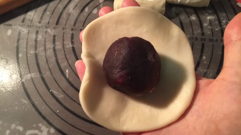 馅中馅月饼,用擀面杖压扁擀大,包上准备好的馅