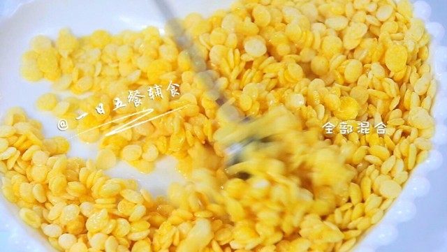 烤玉米片,用勺搅拌均匀,使每一片都均匀的粘上油和蜂蜜。