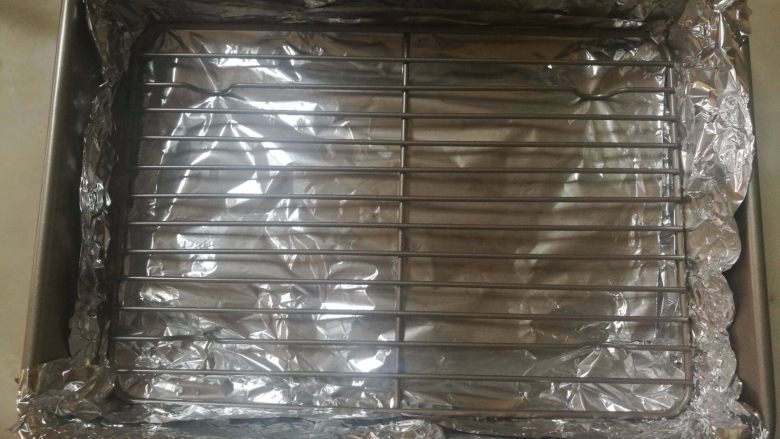 新奥尔良鸡中翅,8.用保鲜膜垫好烤盘底部,省的清洗,到时候直接把锡纸拿掉一扔就好了。
