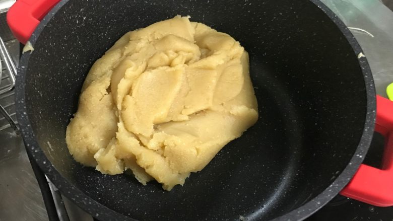 广式莲蓉月饼(自制内馅),馅料形成一整块的状态,用锅铲翻动莲蓉馅,呈现整块挪动的状态
