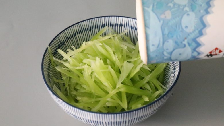 凉拌莴笋,莴笋装入碗中,倒入一勺食用盐。