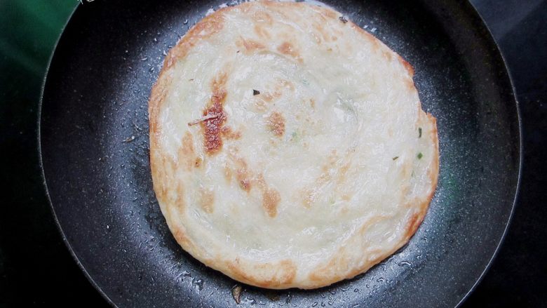 自制手抓饼,早饭又多了个选择,等一面烙成金黄色时，反面，烙另一面。等另一面烙成金黄色的时候，用筷子夹住饼的边缘向中间挤压