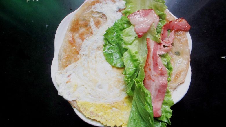 自制手抓饼,早饭又多了个选择,煎好的手抓饼，抹上喜欢吃的酱料，摆上生菜和培根