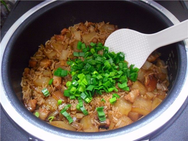 五花肉虾米萝卜焖饭,米饭焖好后响起提示声,打开盖子,倒入蒜叶