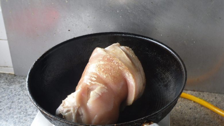 烀肘子, 热油,放入猪肘子煎制,把肉皮两面煎制微微发黄就可以
