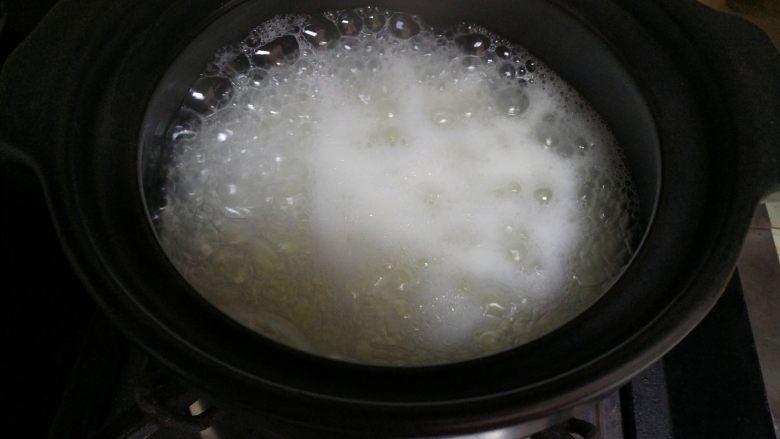豆角煲仔饭,大米煮开后,把小木勺搅拌一下,然后小火焖煮。