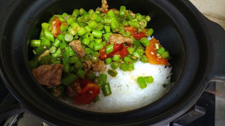 豆角煲仔饭,把炒好的豆角放在快收水的米饭上。