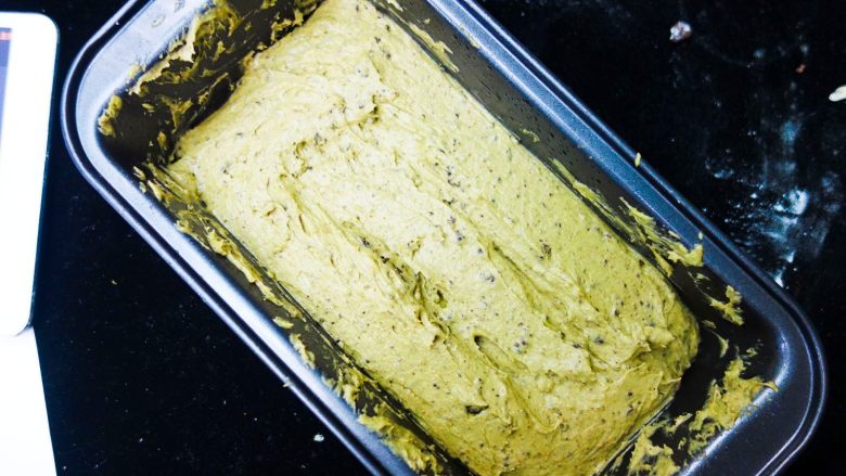 抹茶奥利奥磅蛋糕,模具可以涂黄油撒面粉防粘,也可以直接垫油纸。用刮刀规整好蛋糕坯,中间部分塌陷,