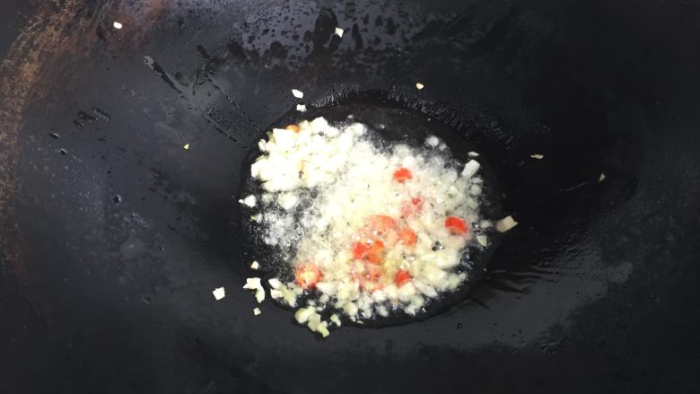 肉末茄子煲,热锅冷油,倒入之前切好的生姜、蒜瓣和小米椒,煸炒出香味;
