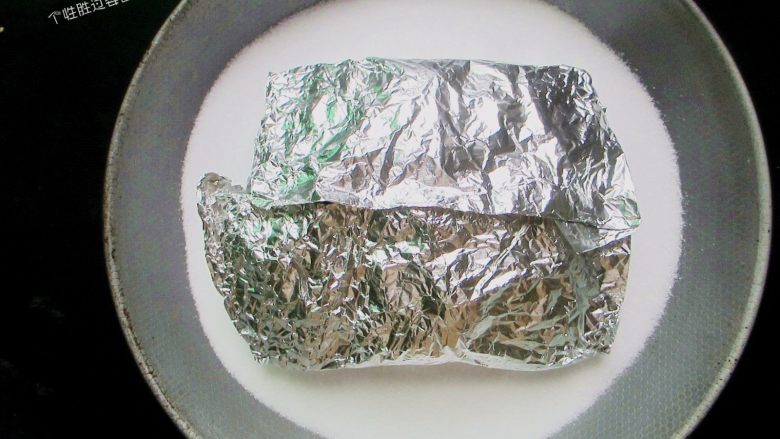 盐焗锡纸金针菇,放入锡纸包,再把余下的盐都倒进锅内,把锡纸包盖住,然后盖上煲盖,用微火慢焗8分钟至熟。