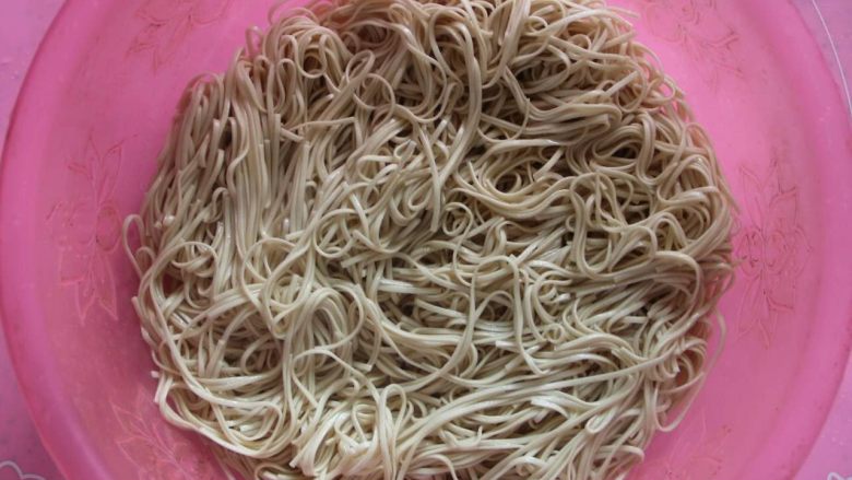 豆角(肉)焖面,快速捞面条起锅,沥水后放入盆中,倒入一些平时炒菜的油,快速搅拌,以防粘连(一定要搅开,不然呆会焖的时候就粘到一起了)