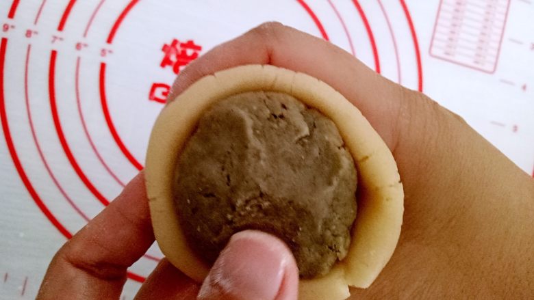 月饼#小胖手作,送礼更要送健康#,我烤了一些面粉,用来防粘连,手上沾些熟面粉把饼皮压扁,包上豆沙馅,