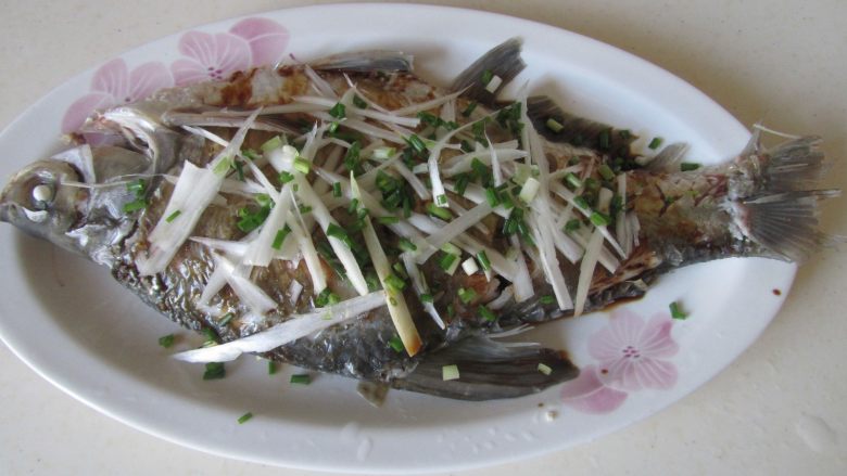 清蒸武昌鱼,再将大葱丝和小葱末摆放在鱼表面;