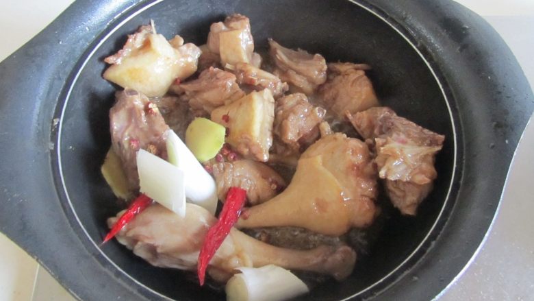 鸭腿烧莴苣,翻炒至鸭子表面微微有些焦黄后加入葱姜蒜和红椒继续翻炒;