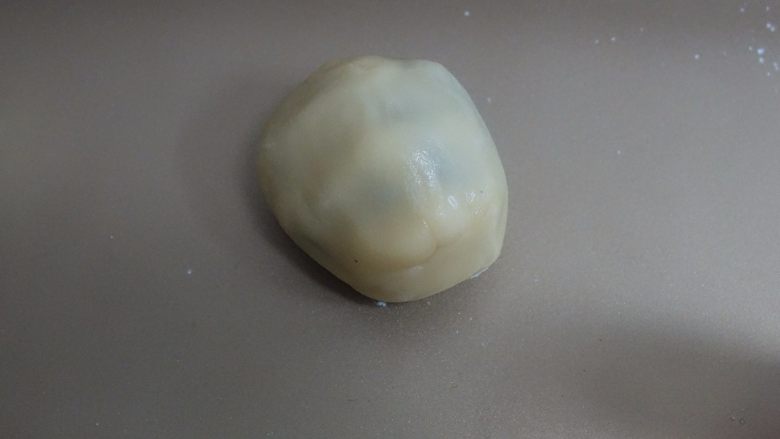 广式莲蓉蛋黄、豆沙蛋黄月饼制作方法,面皮都是糖浆所以很沾手,可以戴手套包,还沾的话可以裹一点点面粉就好包了,饼皮一点点顺着馅料往上推直至收口全部包住,4:6的非常好包没难度,包