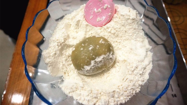 50克广式红豆蓉月饼,在中筋粉里滚一圈,同时模具也撒上干粉,倒出多余的。