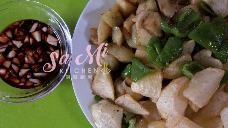 地三鲜(东北传统名菜),将炸好的土豆、柿子椒、茄子装盘,和之前调好的酱汁备用