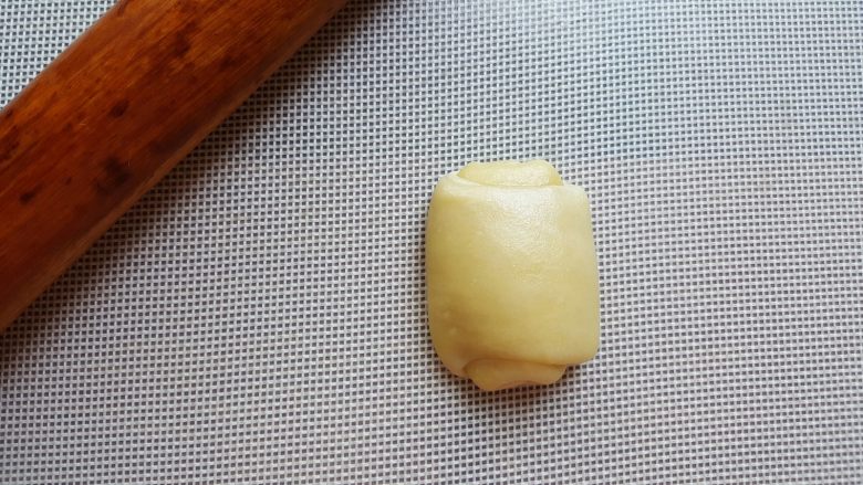 芝麻烧饼,11.将卷好的面团,取一个压扁擀开成长条。