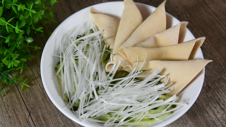 北京烤鸭的亲兄弟“京酱肉丝”家常版版,将豆皮对折摆入盘中,依次放入黄瓜丝、圆葱丝