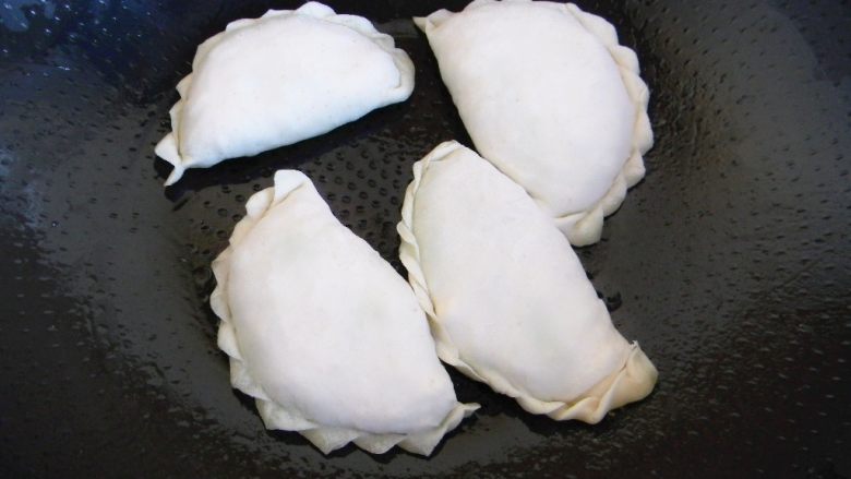 蒜苗鸡蛋小盒子,平底炒勺放油,放入包好的盒子
