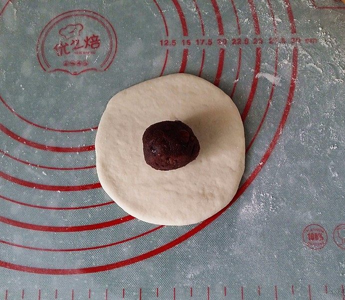 红豆沙包子,取一个剂子擀开,放上一个红豆沙馅