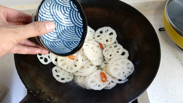 炝炒藕片,然后把调好的白醋和盐的调味汁倒进锅里。