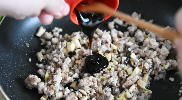 厨师长制作经典名菜之过桥豆腐,再倒入蒜姜末、香菇末翻炒，炒匀后倒入15g<a style='color:red;display:inline-block;' href='/shicai/ 721'>蚝油</a>