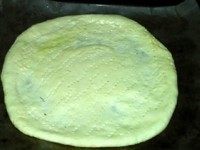 火腿批萨,放入烤盘,用叉子在饼皮上叉若干小孔,刷一层油,醒发20分钟