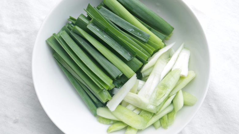 川味回锅肉,蒜洗净,蒜白斜刀切,蒜青直刀切;