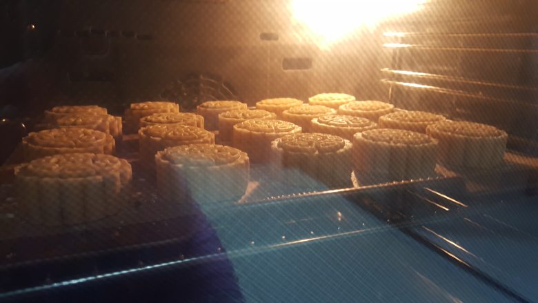 椰蓉枸杞月饼,19.放入预热好的烤箱中上下火200度中层烤6分钟,取出在月饼表面刷蛋黄水,不要刷得太厚,薄薄一层即可,再放入烤箱中190度,烤13分钟。