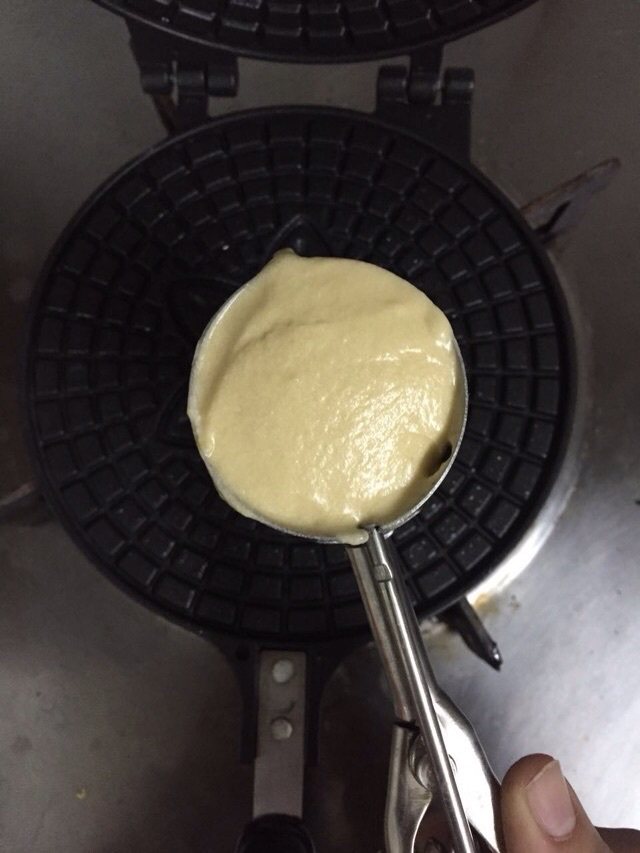 桑葚脆皮冰淇淋,蛋卷锅两面刷油,中小火预热,用挖雪糕的勺子装一勺,放入中心,然后盖上。见有蒸汽就反面,烧好后熄火。