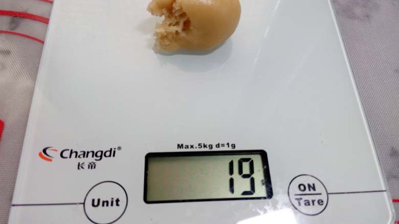 广式月饼~莲蓉蛋黄月饼,先称饼皮,尽量保证每一份称量准确。饼皮和馅按3:7或2:8比例分好。例如包50克的,馅料重35克(蛋黄的重量也计算在内),皮15克。不熟练可以按4:6来做,馅30克,皮20克,会好包些。
我做的是63克的月饼。饼皮称重19克。