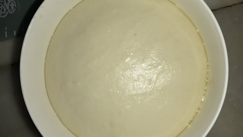 牛肉包,发酵好的面团,工作台上洒上高粉,把面团取出,用手掌排气压扁