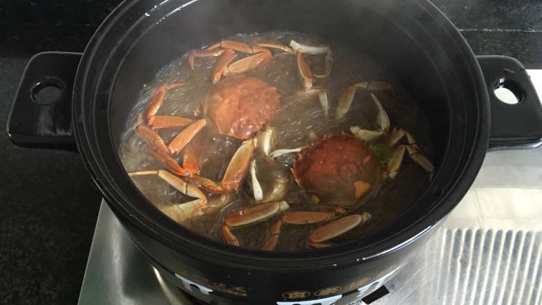 大闸蟹粉丝煲,煮至沸腾后再转小火煮3-5分钟即可,可以撒上适量葱花点缀一下。