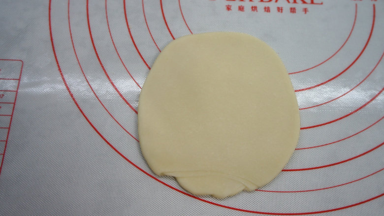 一咬直掉渣儿的蛋黄酥,取一个饧好的面卷,按扁,再擀成尽量圆的皮,边缘薄一些;