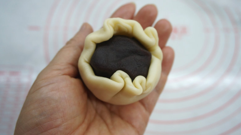 一咬直掉渣儿的蛋黄酥,将蛋黄豆沙放在圆皮中间,四周向内聚拢;