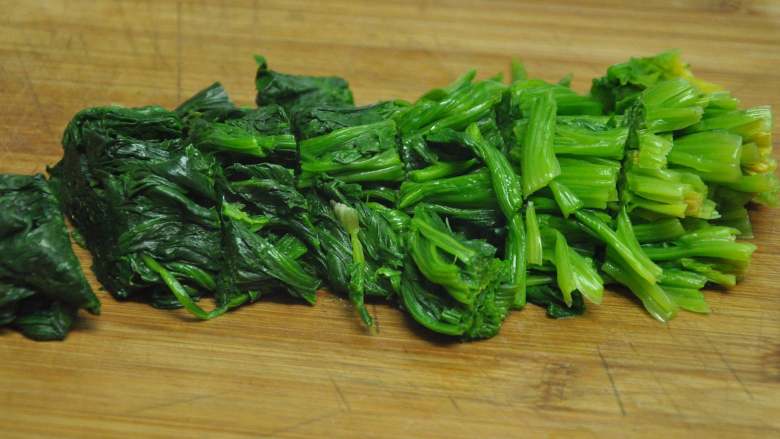 绿色美食麻酱果仁菠菜,取出菠菜挤干水份,切成约3厘米的段