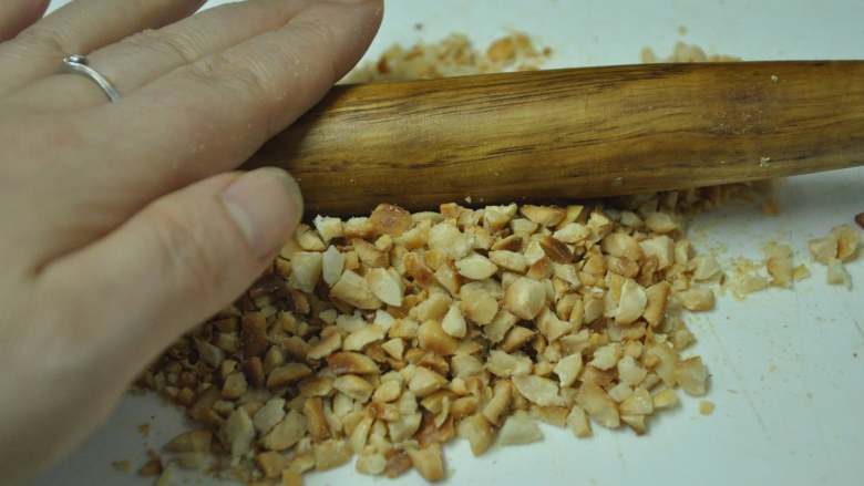 绿色美食麻酱果仁菠菜,花生米晾凉后去皮,用擀面杖擀碎