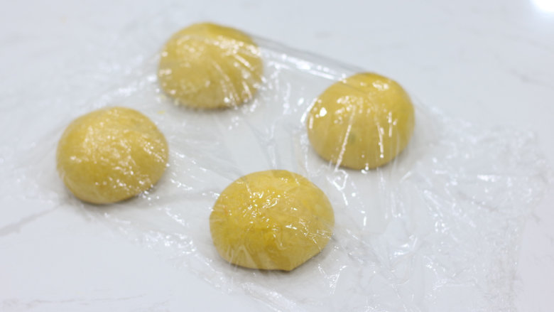 丰收的季节——金色南瓜吐司,平均分割为4个面团,滚圆后覆盖保鲜膜松弛20分钟。(也可以分成2份,做一卷的)