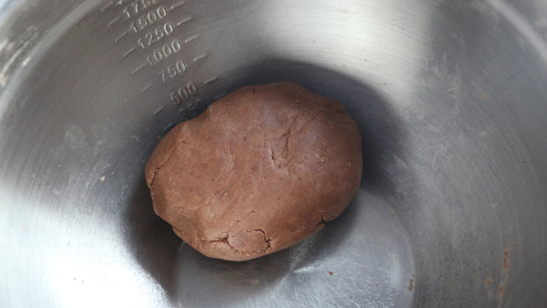 可可玛格丽特饼干,揉成面团。揉好的面团的状态应该是略微偏干,不过份湿润,也不会因为干燥而散开。
揉好的面团装入保鲜袋内,冰箱冷藏1小时,冷藏后的面团更为干硬,用拇指按的时候更容易裂出漂亮的裂纹,如果没有条件,也可以不冷藏。