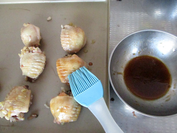 八宝酿鸡翅,蒸好的鸡翅放入烤盘中,刷一点蜜醋汁。蜜醋汁配比:蜂蜜1勺、白醋1勺,生抽半勺,搅拌均匀即可