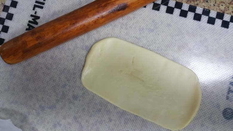 中式点心~白酥皮玫瑰鲜花饼(素油版),11.取一个面团,用擀面杖擀成椭圆形。