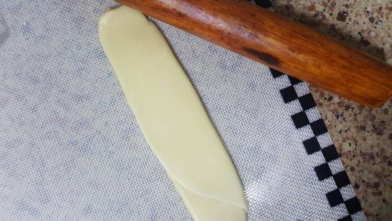 中式点心~白酥皮玫瑰鲜花饼(素油版),13.取一个面胚,用手轻轻压扁。压扁后,再用擀面杖擀长