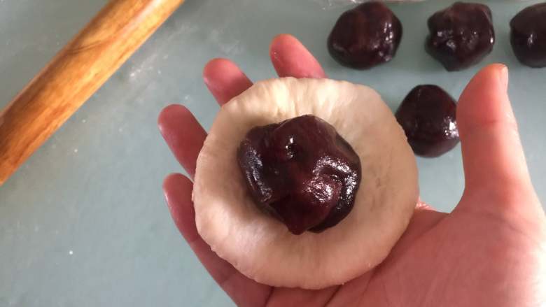胖企鹅挤挤包,取一个白色面团擀成圆片,包上豆沙馅
